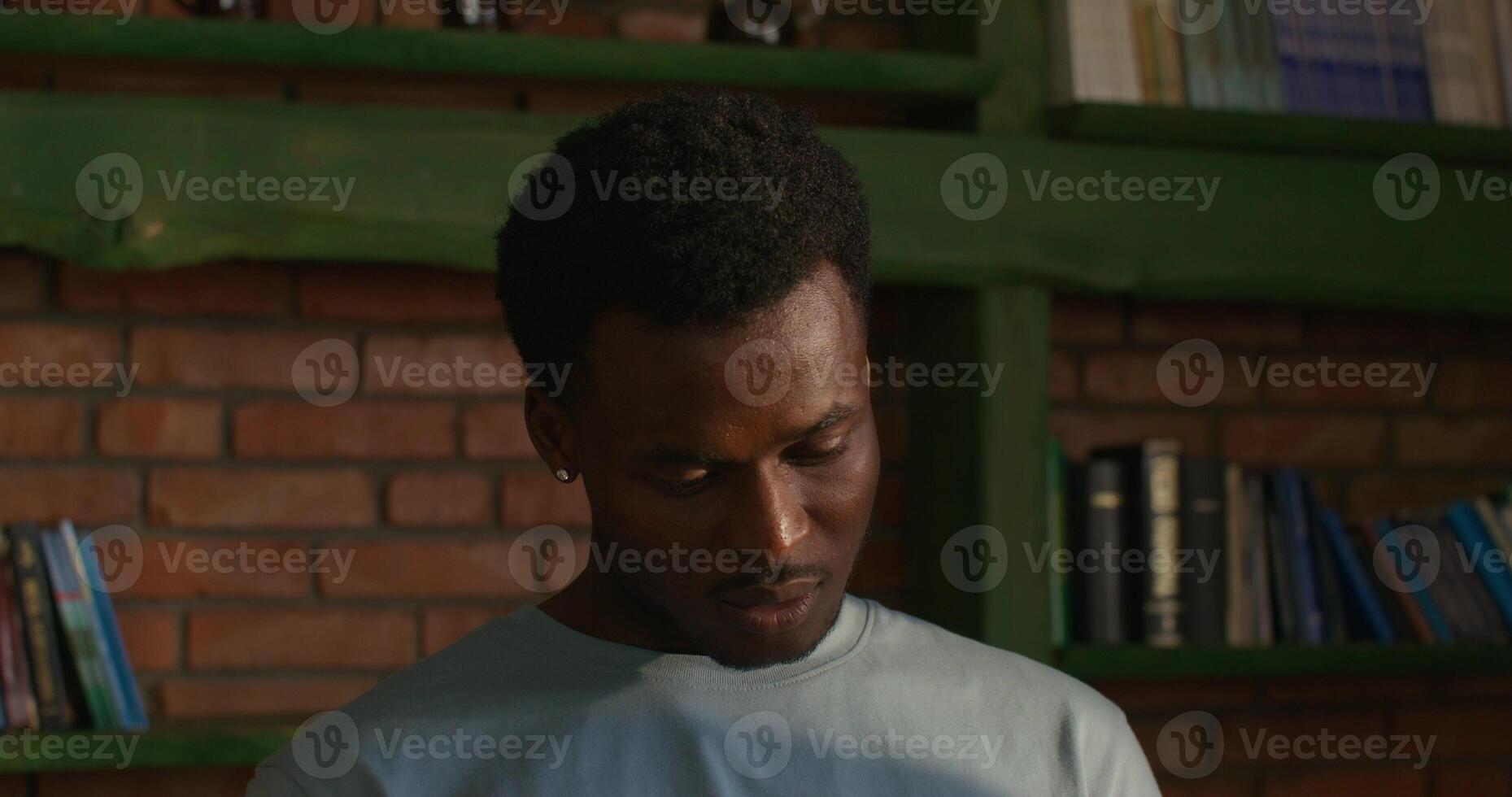 A man is looking at a book on a shelf photo