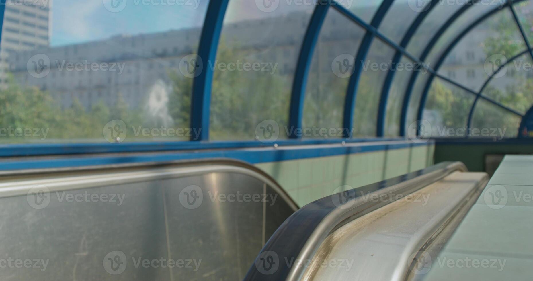 A long escalator with a bench on the side photo