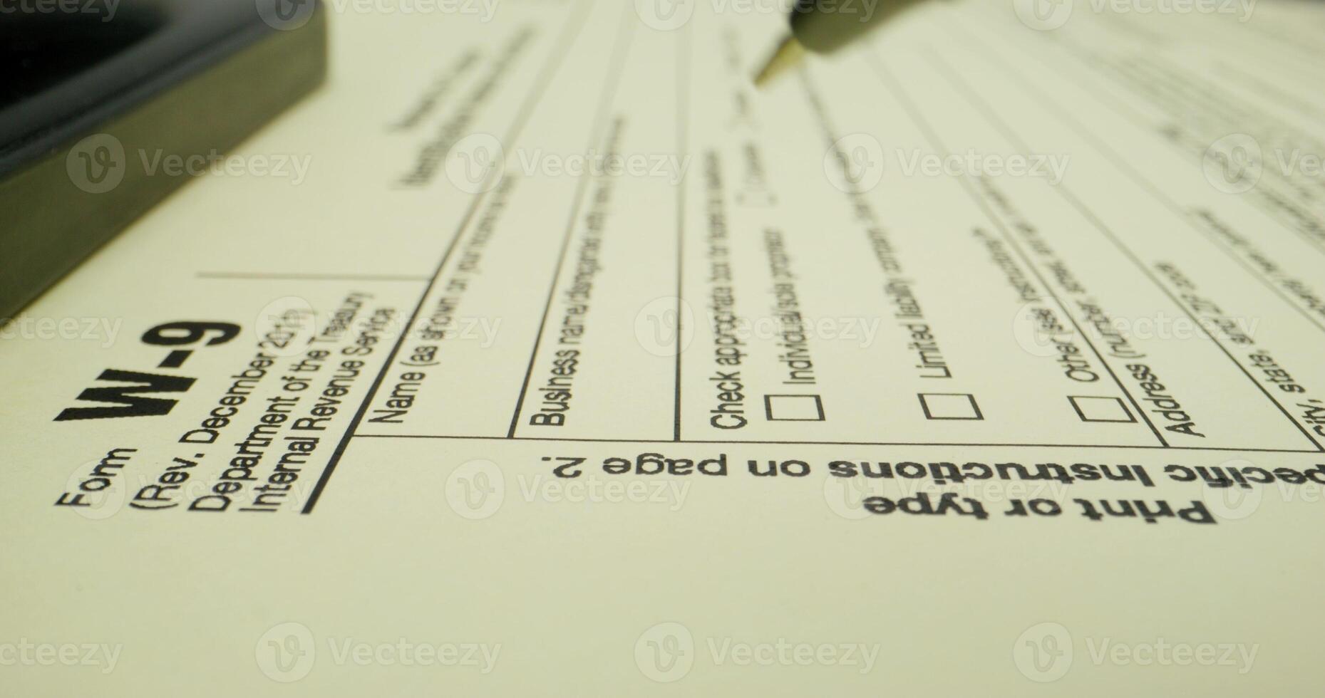 A tax form with a pen and a calculator photo