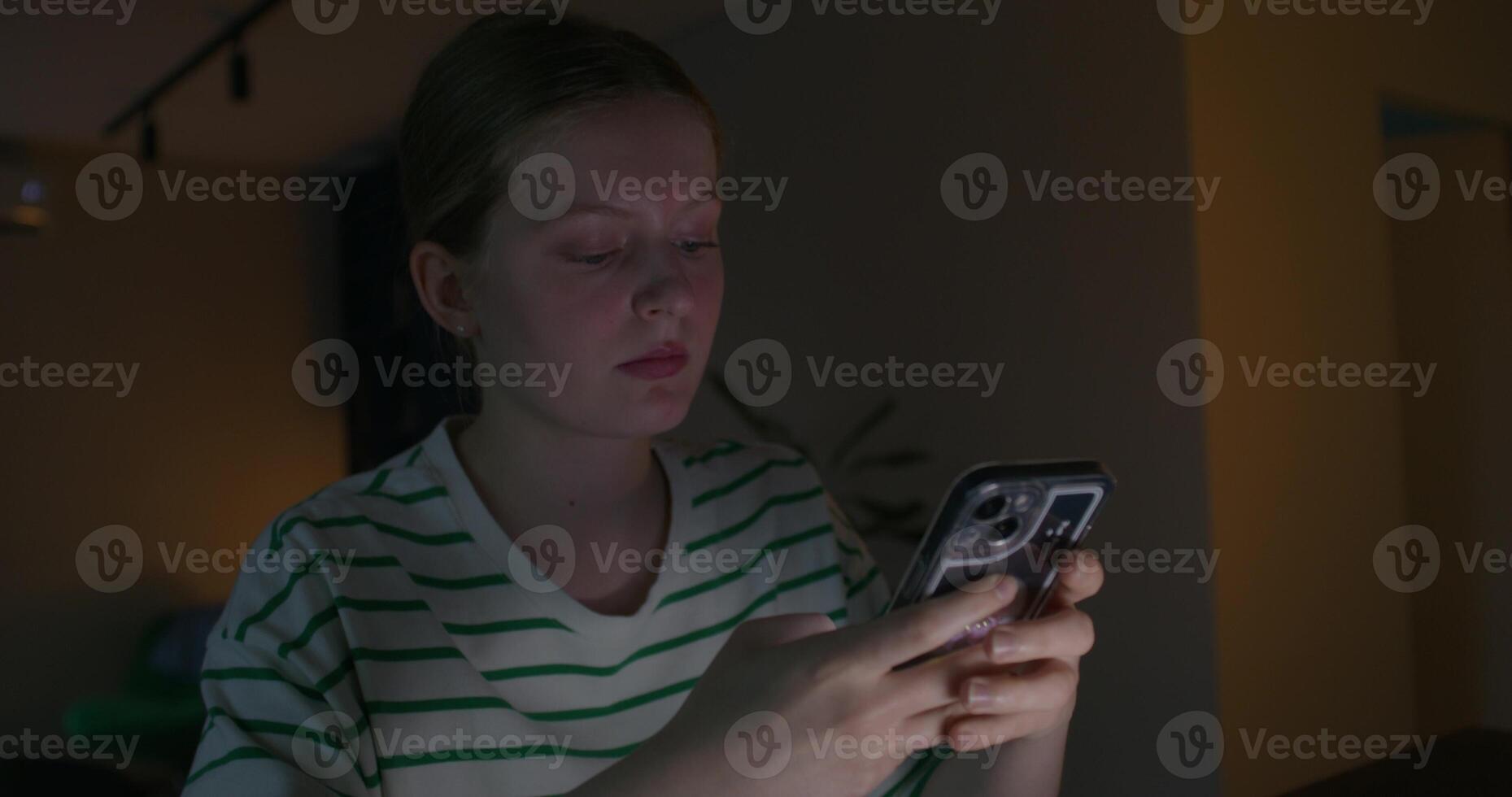 A woman is looking at her phone at night photo