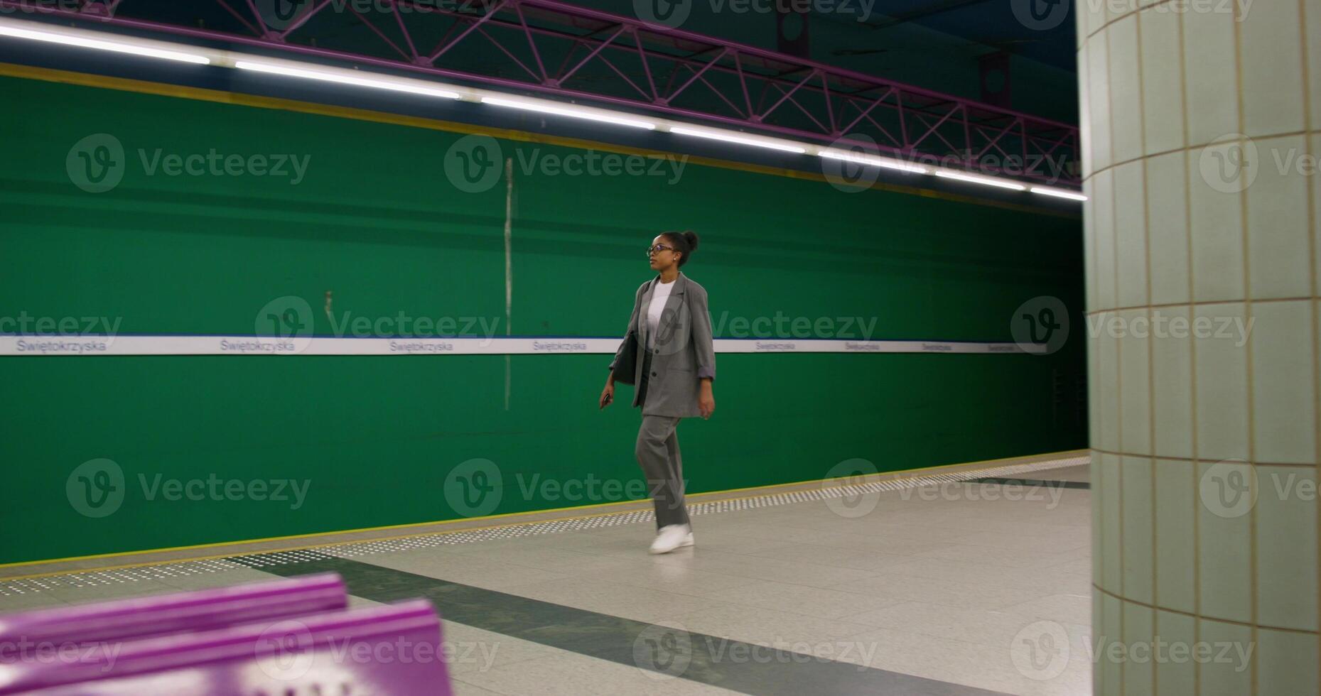 A man in a suit is walking down a subway platform photo
