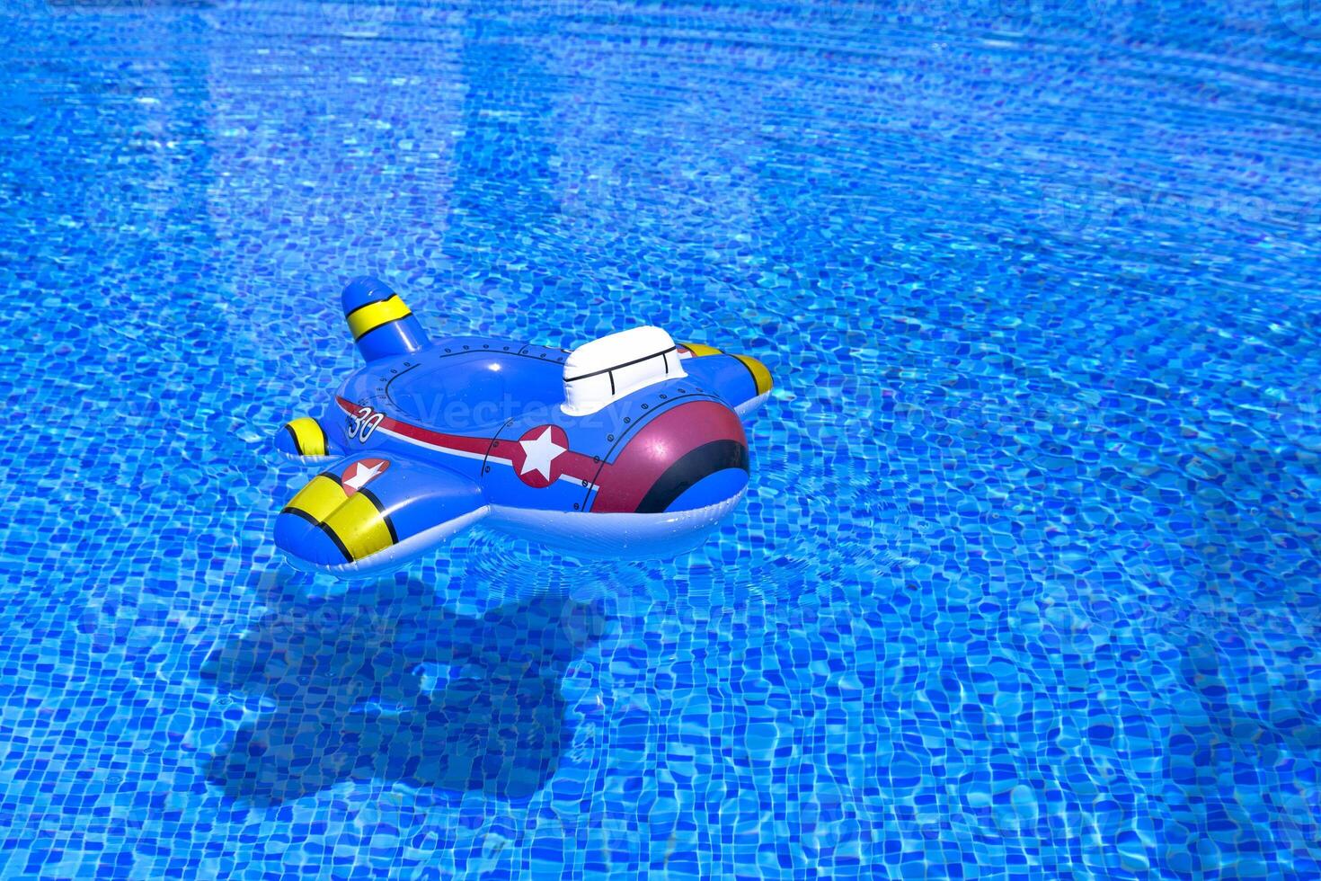 Children's inflatable lifebuoy on the water surface of the pool photo