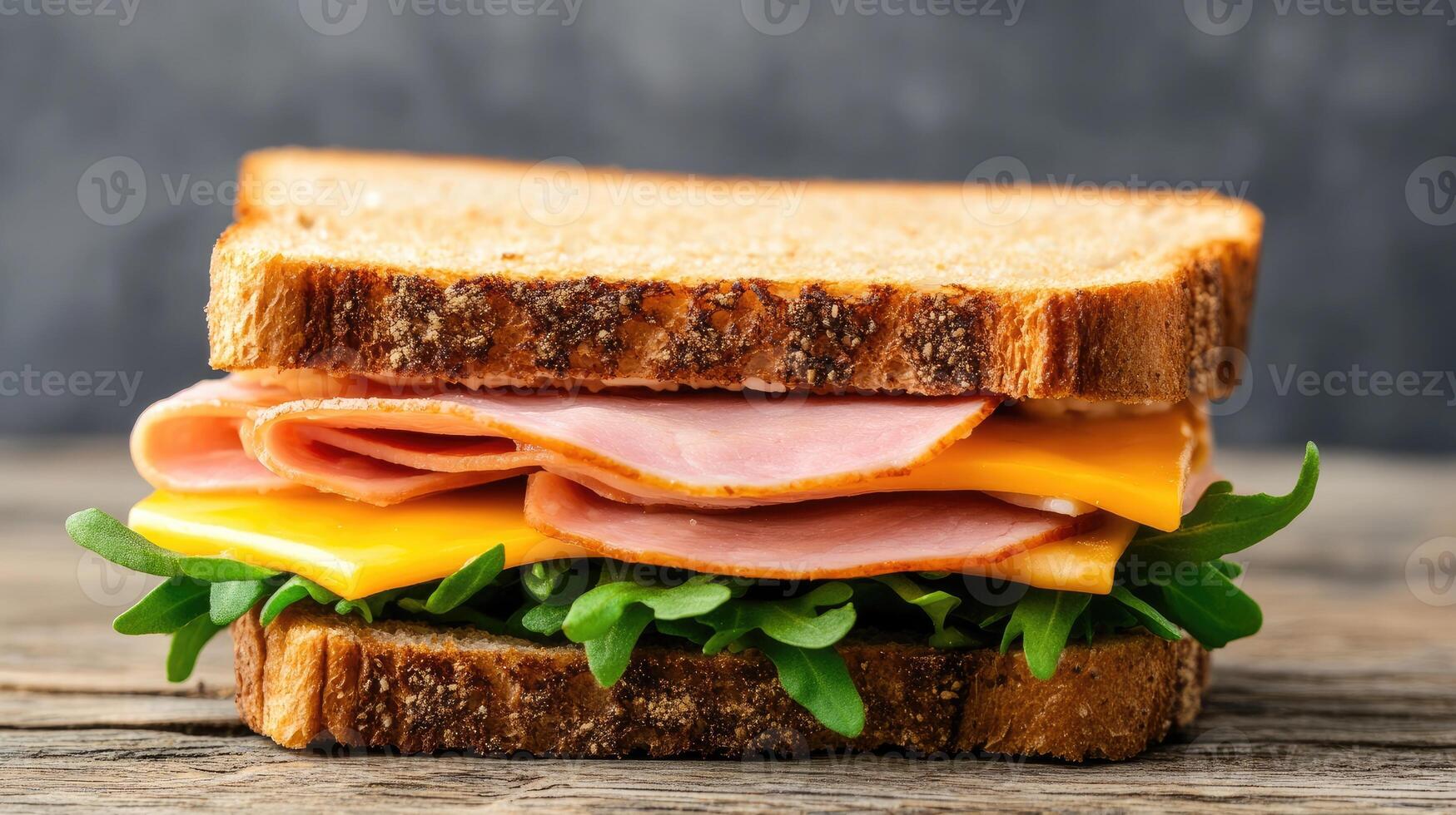 Delicious sandwich with layers of ham, cheddar cheese, and fresh greens on whole grain bread. photo