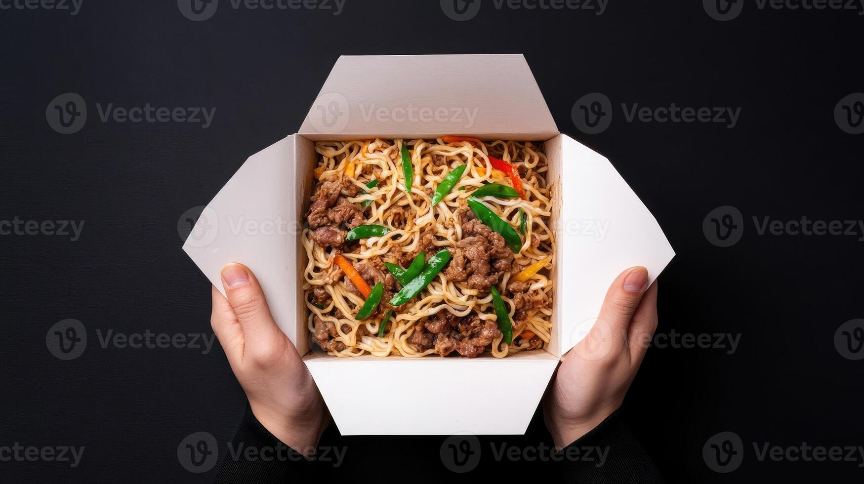 Delicious stir-fried noodles with vegetables served in a takeout box. photo