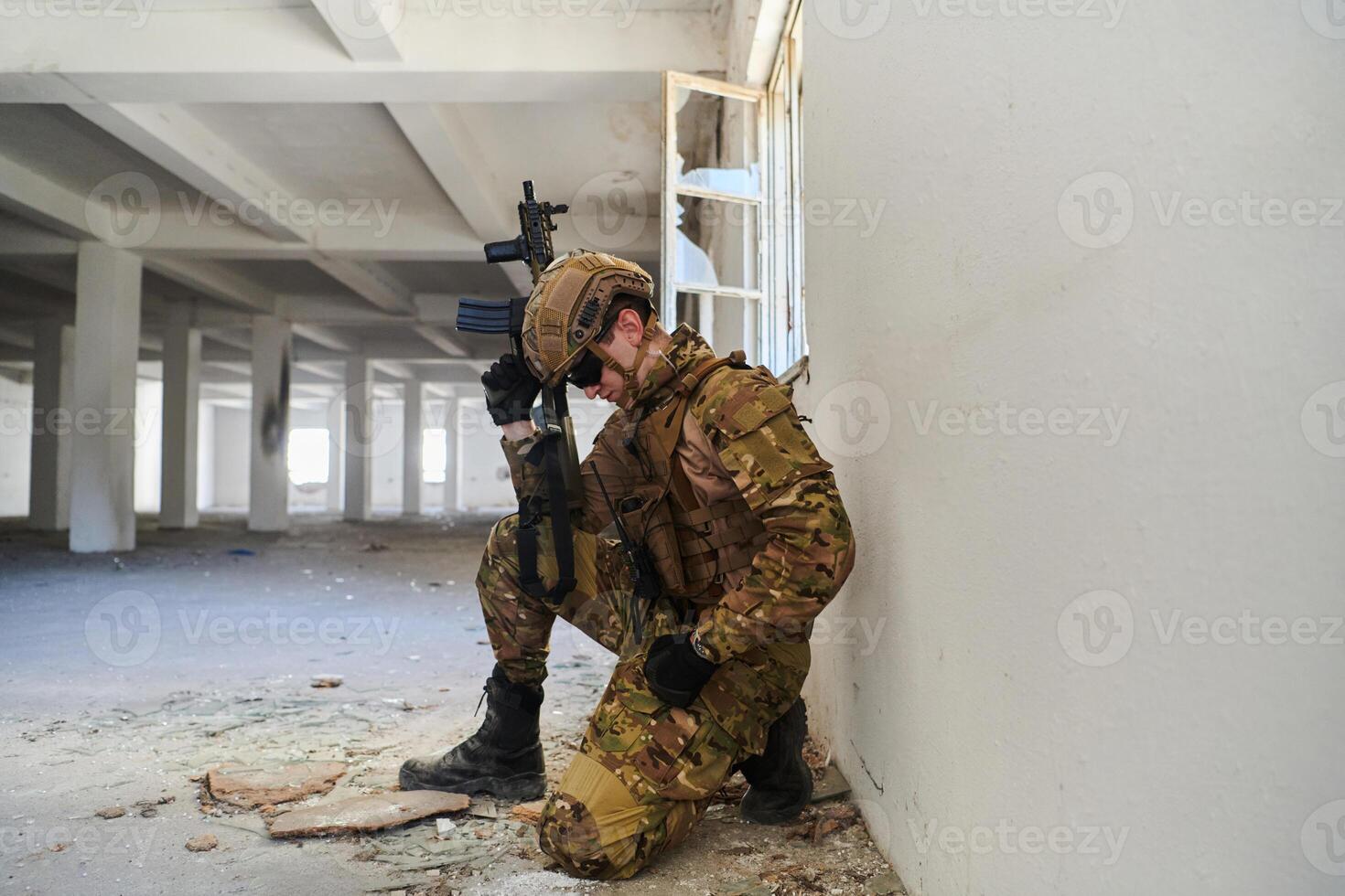 Soldier in action near window changing magazine and take cover photo