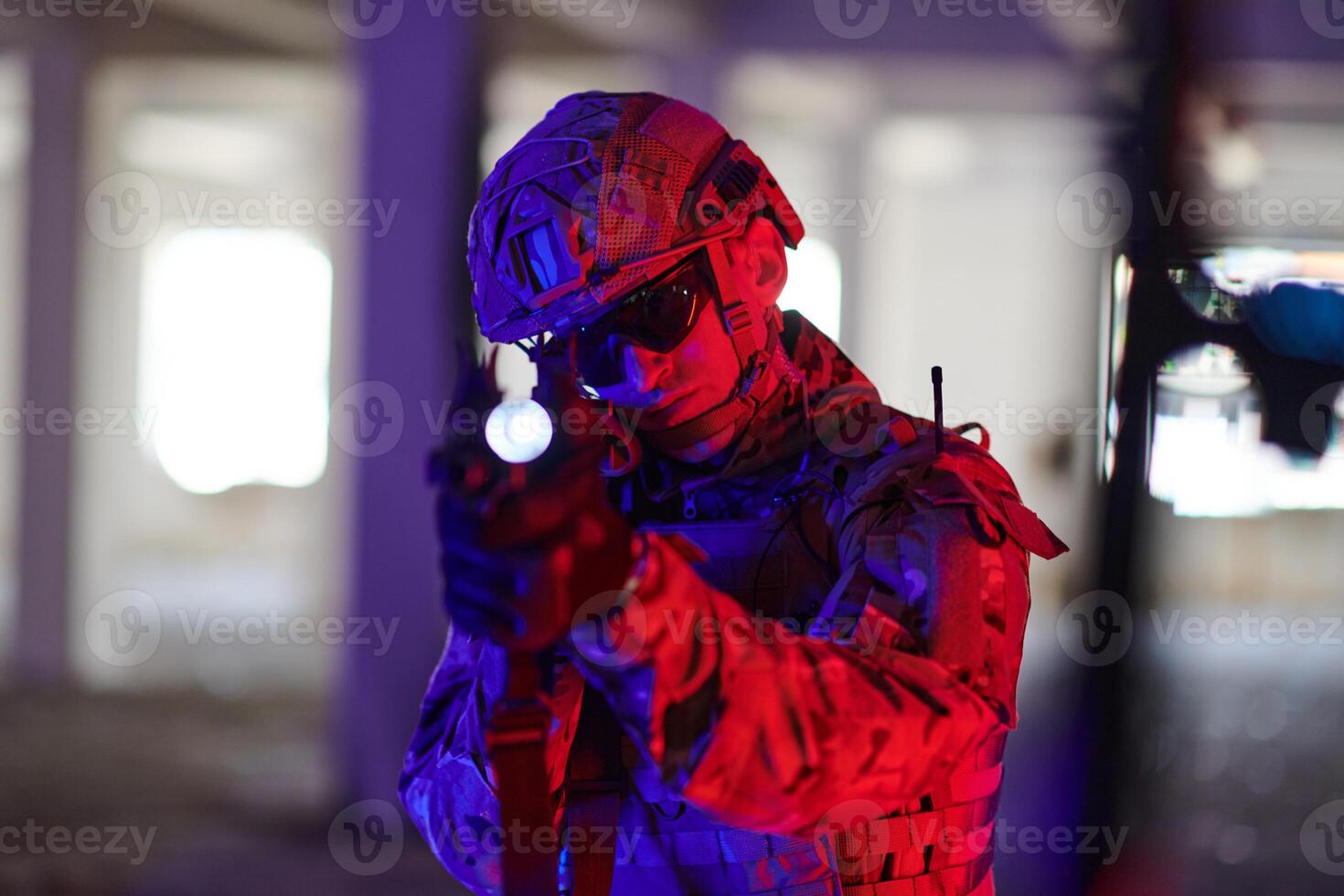 A professional soldier undertakes a perilous mission in an abandoned building illuminated by neon blue and purple lights photo