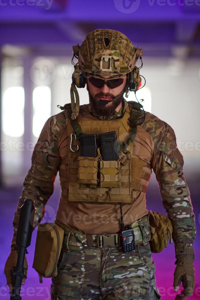 A professional soldier undertakes a perilous mission in an abandoned building illuminated by neon blue and purple lights photo