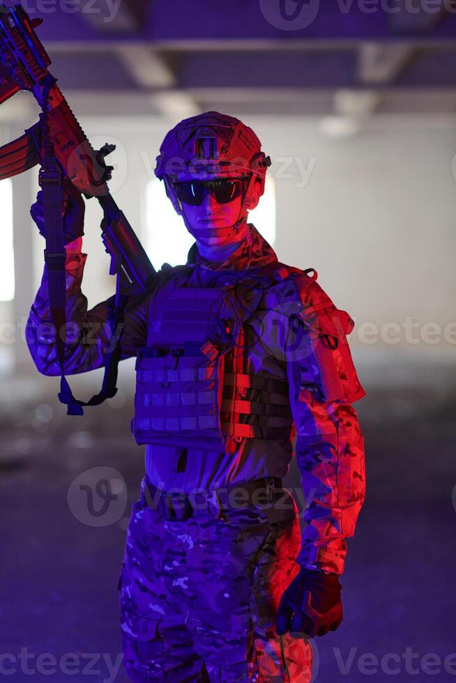 A professional soldier undertakes a perilous mission in an abandoned building illuminated by neon blue and purple lights photo