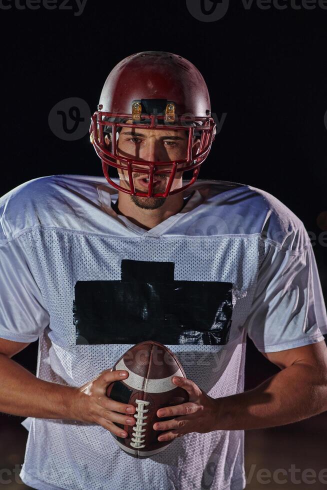 American Football Field. Lonely Athlete Warrior Standing on a Field Holds his Helmet and Ready to Play. Player Preparing to Run, Attack and Score Touchdown. photo