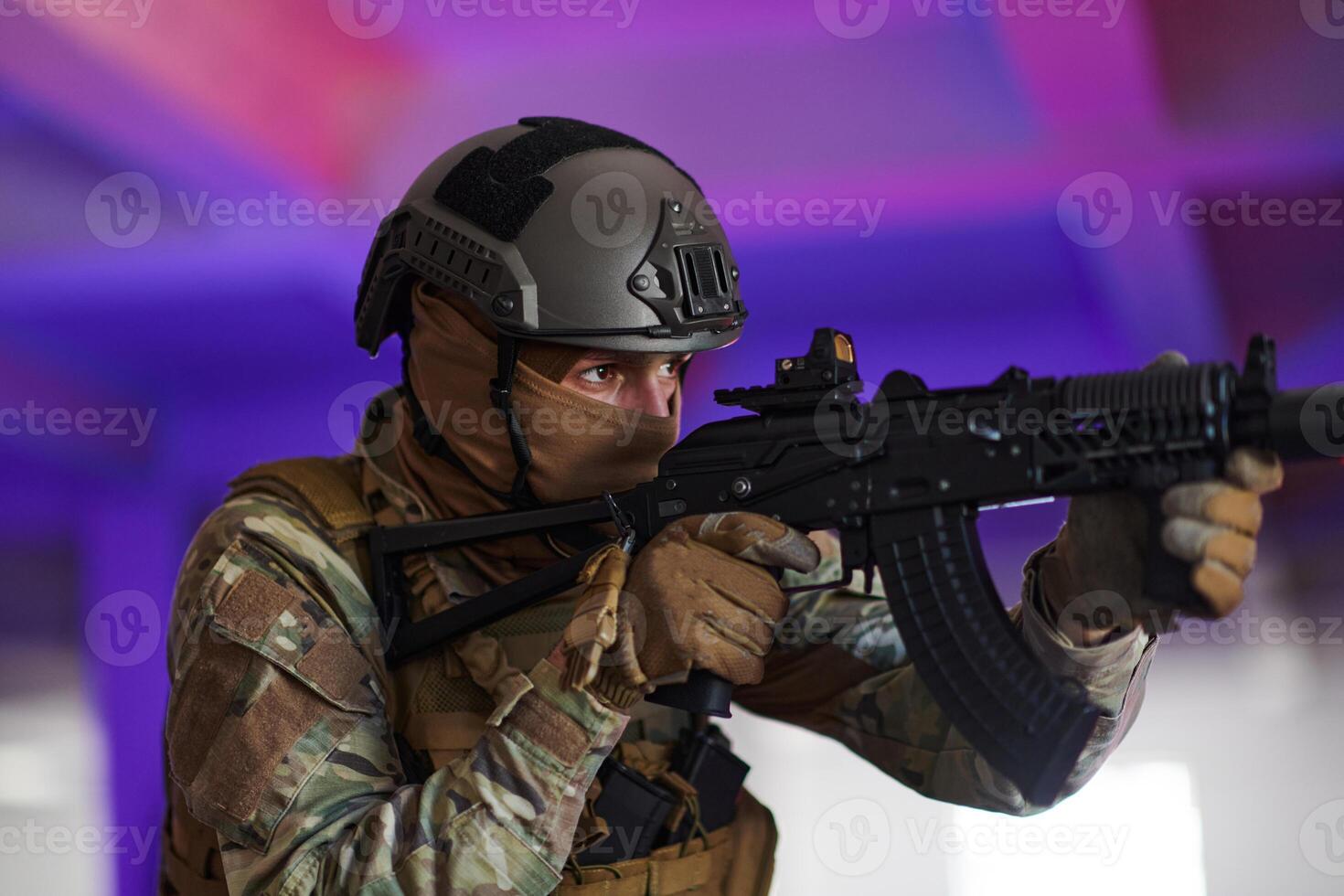 A professional soldier undertakes a perilous mission in an abandoned building illuminated by neon blue and purple lights photo