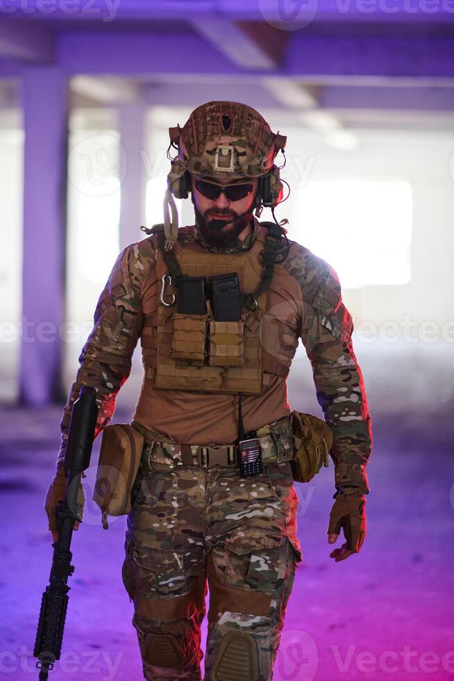 A professional soldier undertakes a perilous mission in an abandoned building illuminated by neon blue and purple lights photo