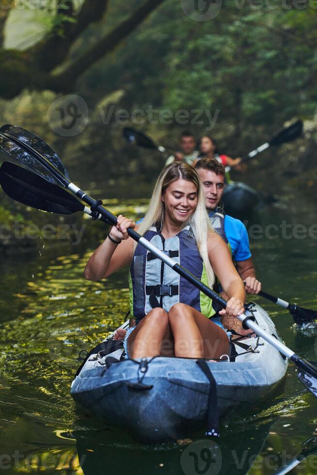 A group of friends enjoying having fun and kayaking while exploring the calm river, surrounding forest and large natural river canyons photo