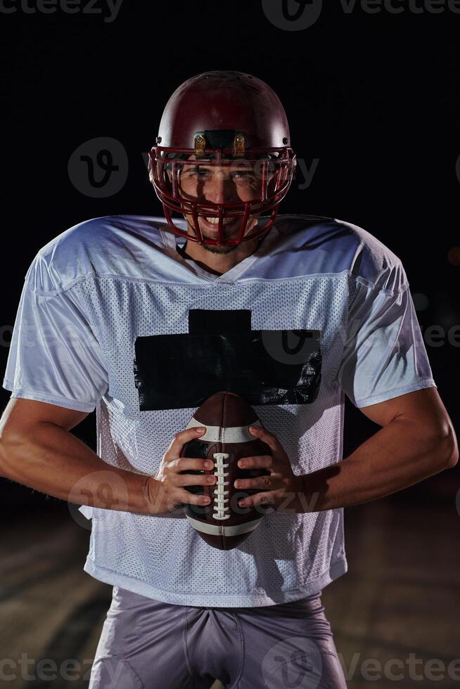 American Football Field. Lonely Athlete Warrior Standing on a Field Holds his Helmet and Ready to Play. Player Preparing to Run, Attack and Score Touchdown. photo