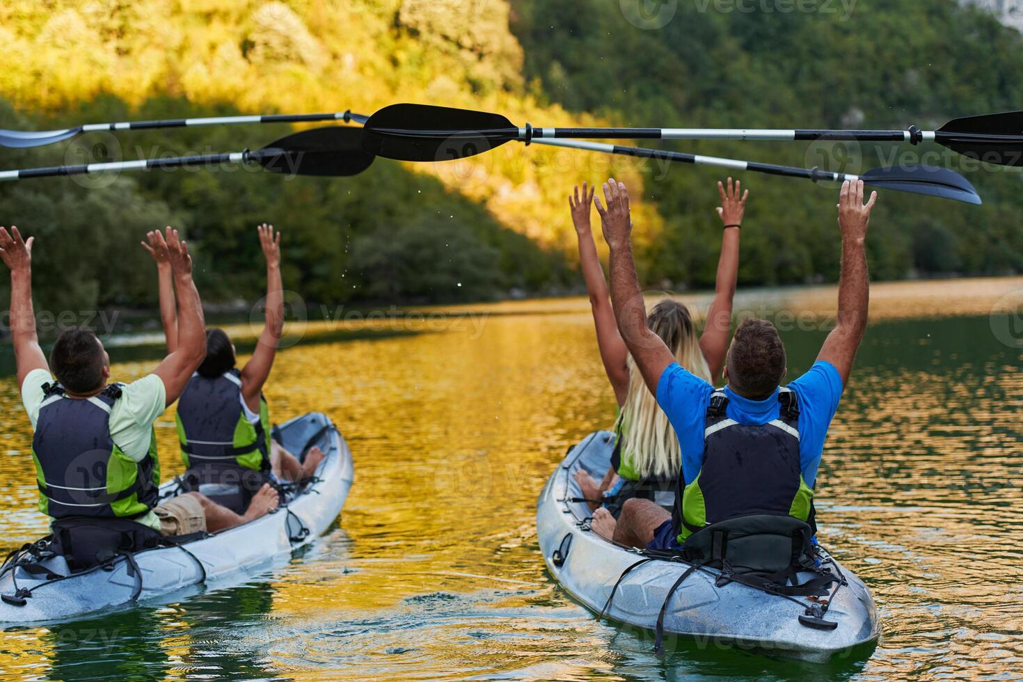 A group of friends enjoying having fun and kayaking while exploring the calm river, surrounding forest and large natural river canyons photo