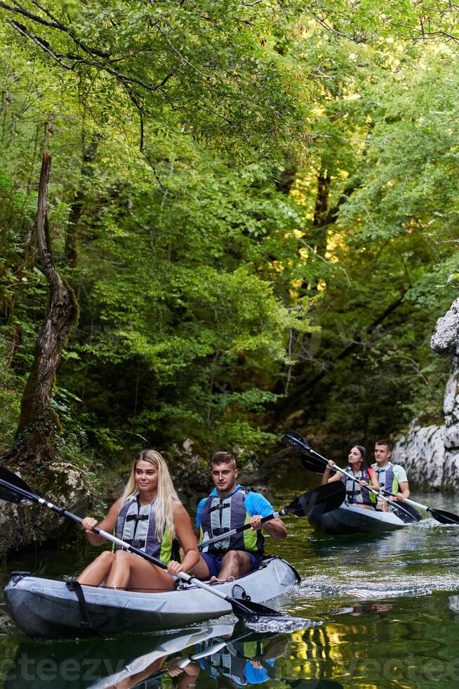 A group of friends enjoying having fun and kayaking while exploring the calm river, surrounding forest and large natural river canyons photo