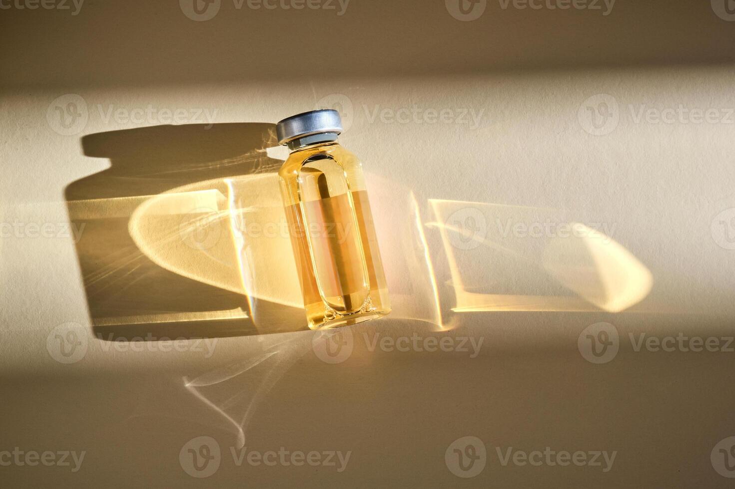 Injection vial with medicinal product in sunlight on beige background. photo