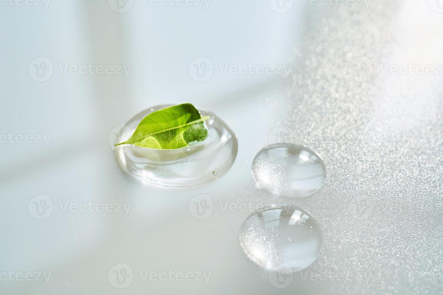 Drop of face serum with green leaf on white background. photo
