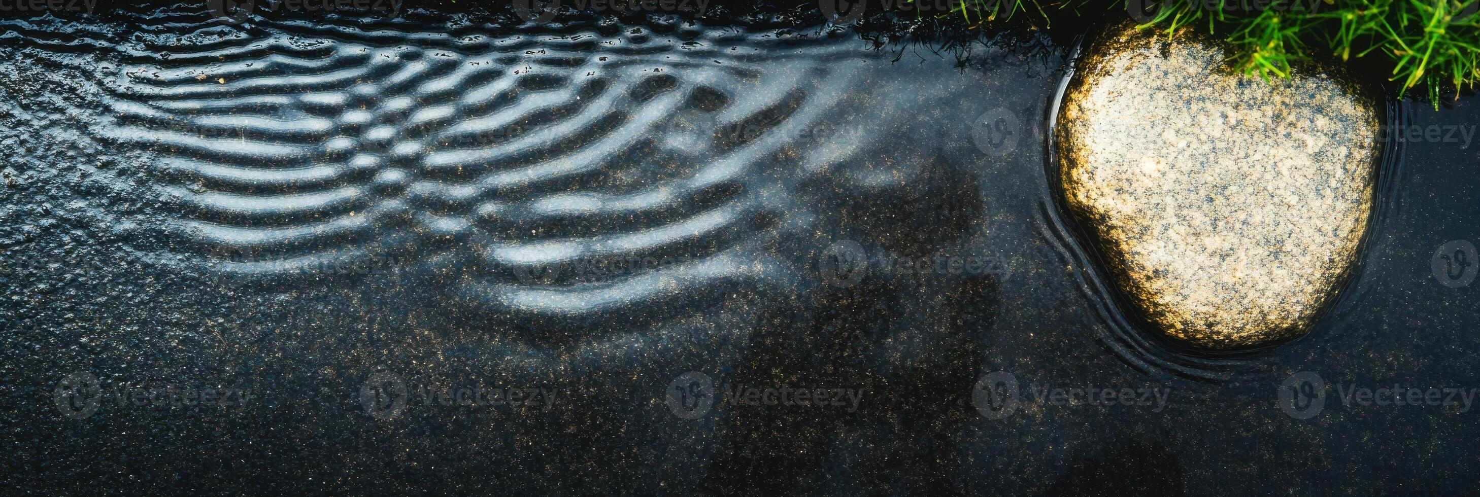 Raindrops creating ripples on water surface near stone and grass in nature photo