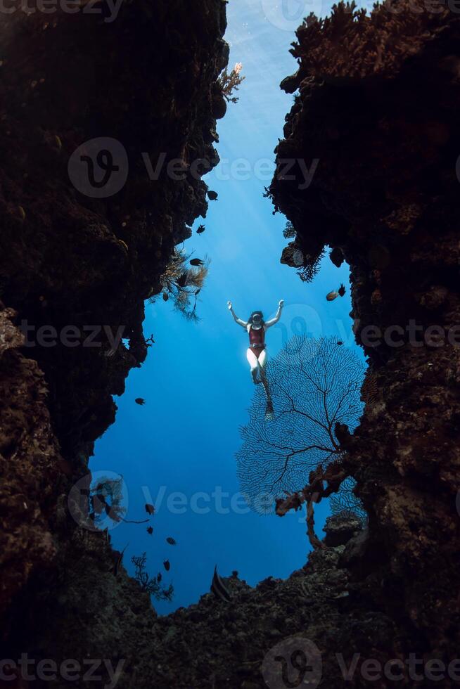 Woman freediver posing in underwater cave in Menjangan photo