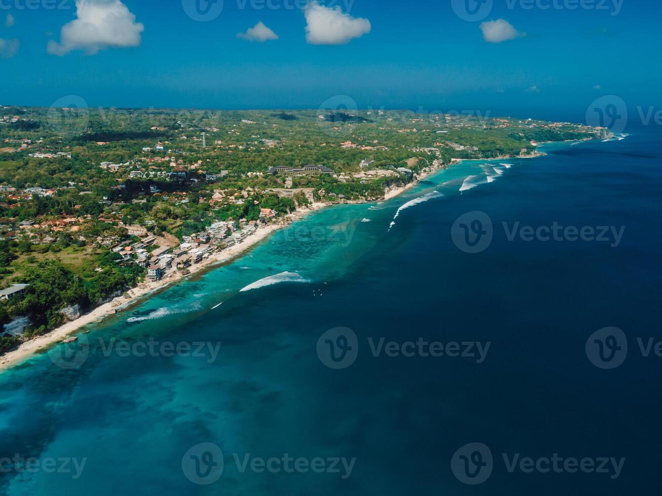 Above shot of coastline in Bali with waves in ocean, drone view photo