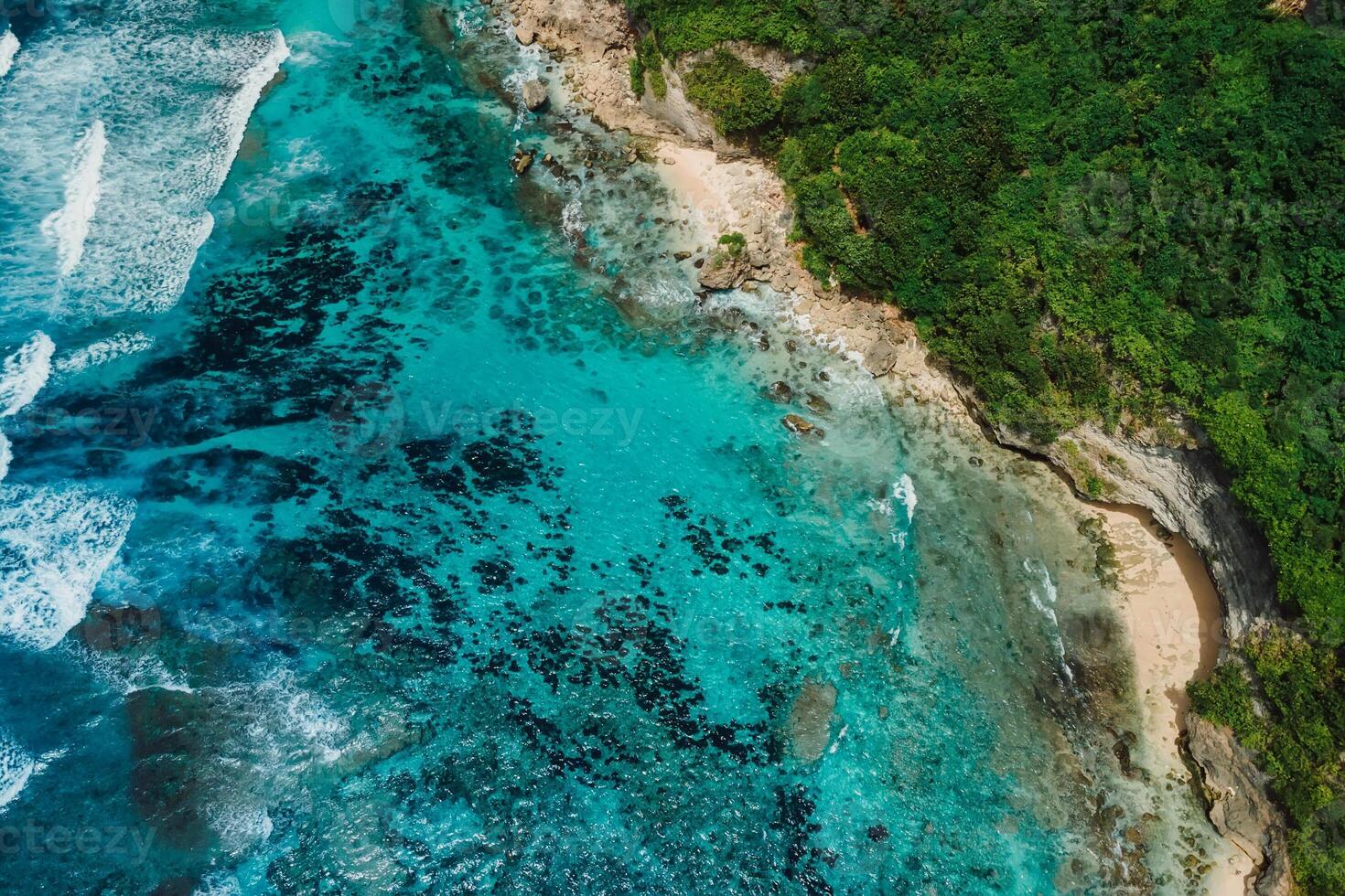 Coastline with turquoise clear ocean and green cliffs in Bali. Aerial view of tropical island photo