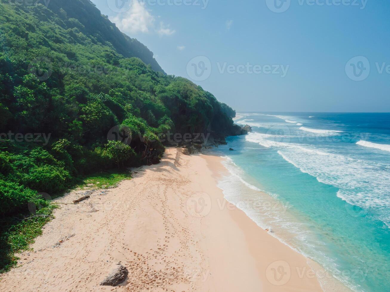 Drone view of beach with blue ocean and waves, sunny day in Bali. photo