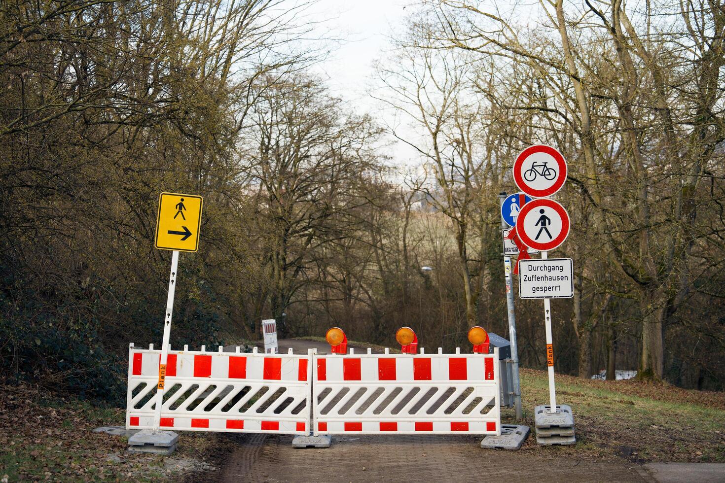 Stuttgart, Germany 25 February 2025. Temporary fencing on a pedestrian path with road signs in Germany. An organized approach in Germany to safety during roadworks or repairs. photo