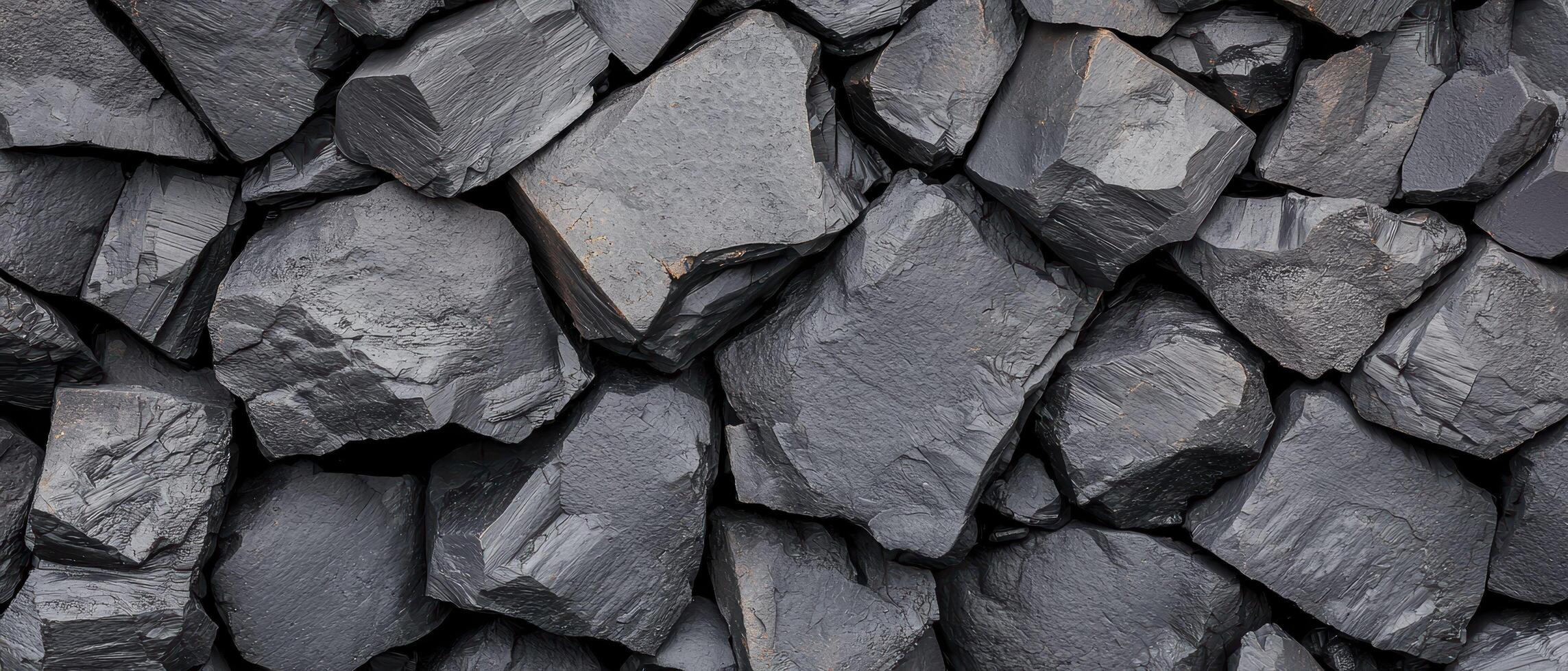 Dark crushed rocks close up texture showing rough, fractured surfaces with jagged edges. The irregular stone arrangement highlights a rugged and natural geological pattern. photo