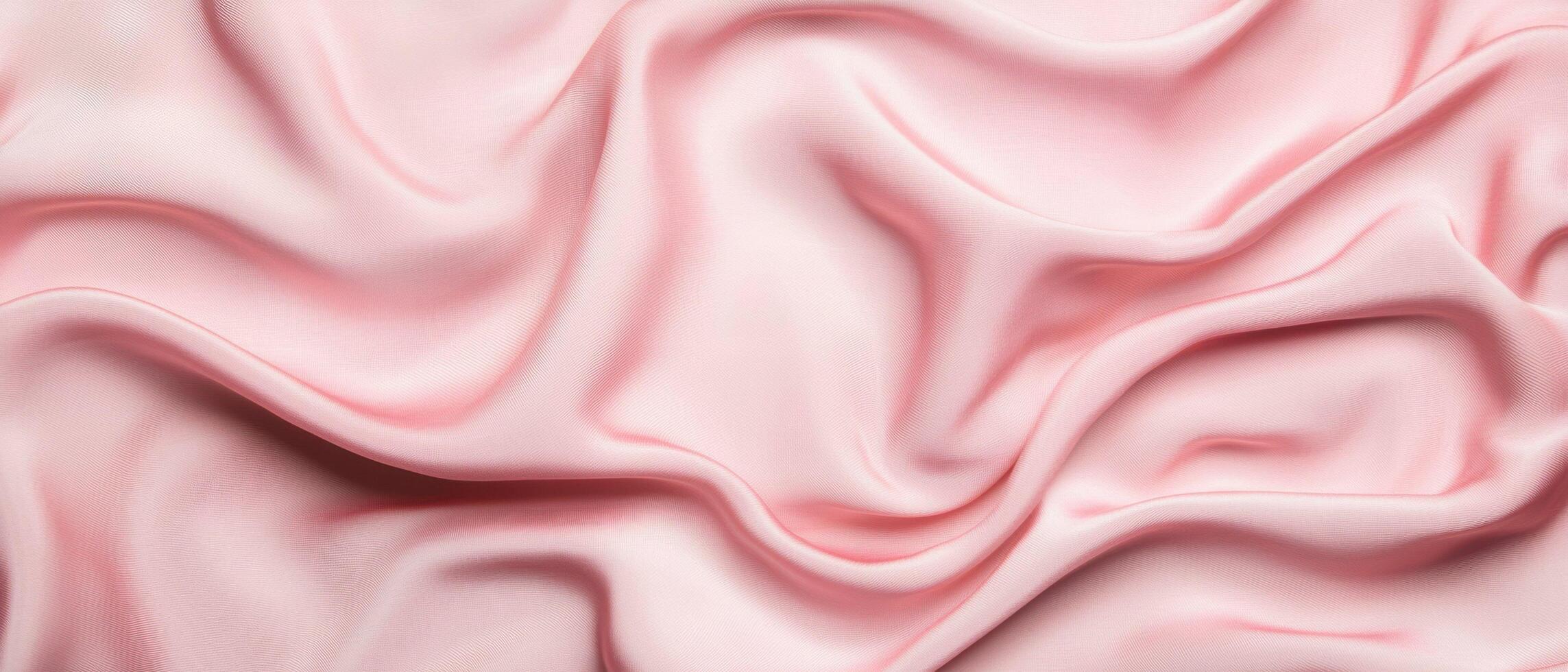Soft pink silk fabric with elegant folds creating a smooth and luxurious texture. The gentle draping and subtle shadows enhance the delicate appearance of the textile. photo