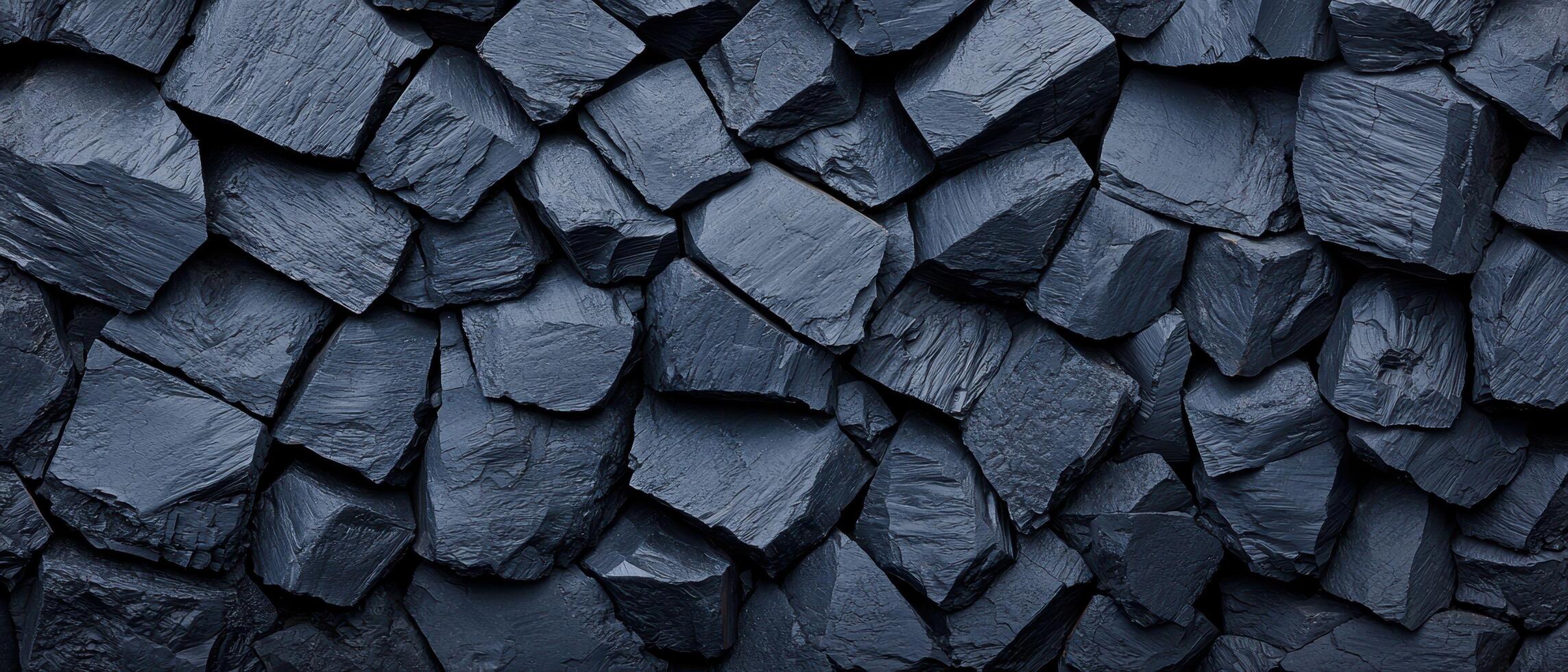 Black crushed rocks close up texture showing sharp, irregular shapes and rough surfaces. The dark stones create a rugged and natural pattern, emphasizing the raw, unpolished appearance. photo