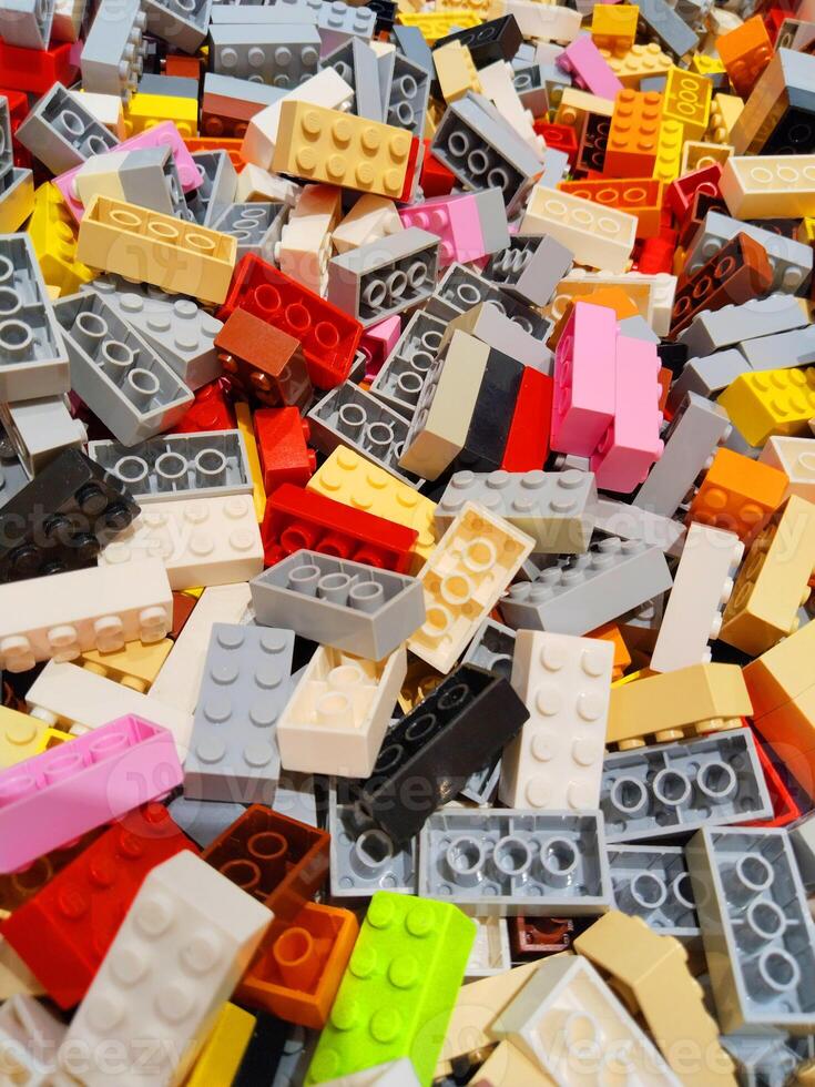 Patterns of brightly colored plastic toy blocks including yellow, pink, red, white, blue and grey. photo