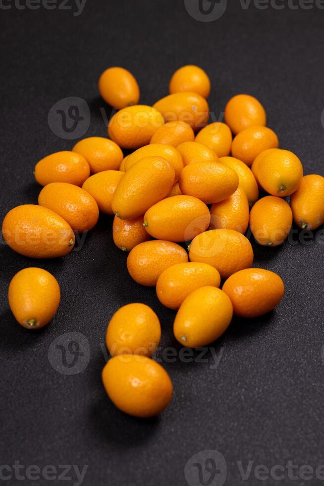 Kumquats lying on a dark background photo