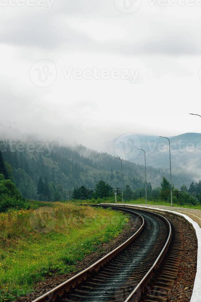 Mountain misty landscape with railway track photo