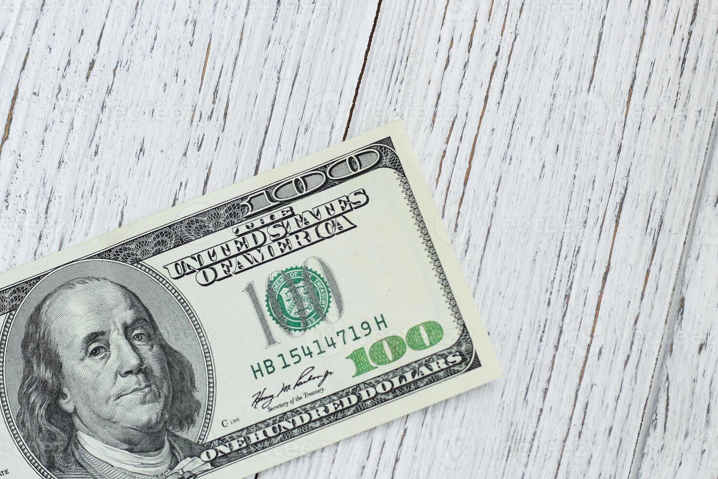 Bills 100 dollars on a wooden background photo