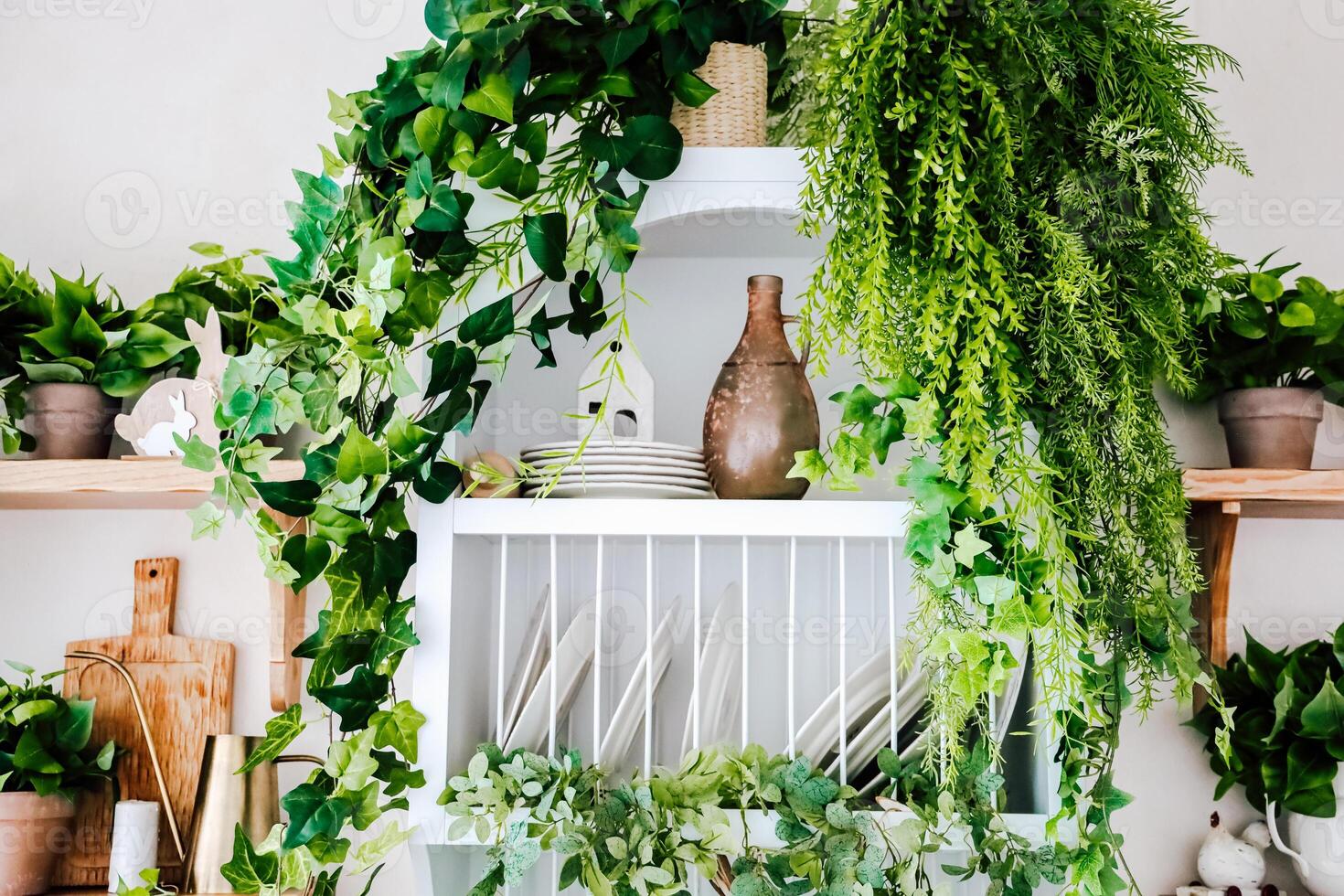 Green plants and rustic decor enhance a stylish kitchen shelf display with natural elements photo