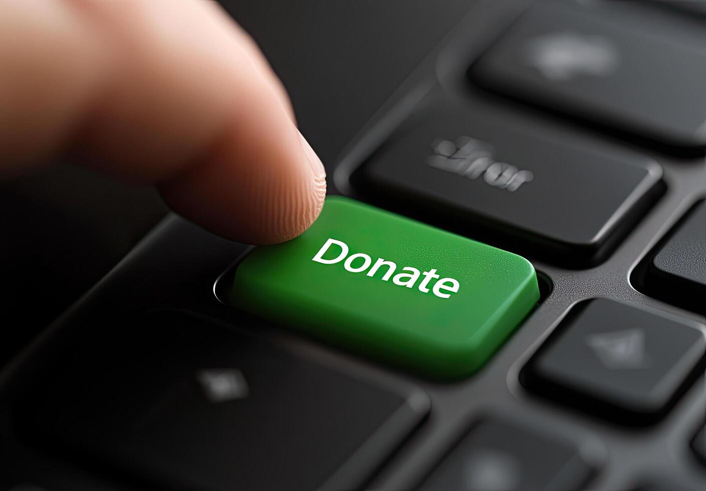 Close Up Finger Pressing Green Donate Button on Keyboard photo