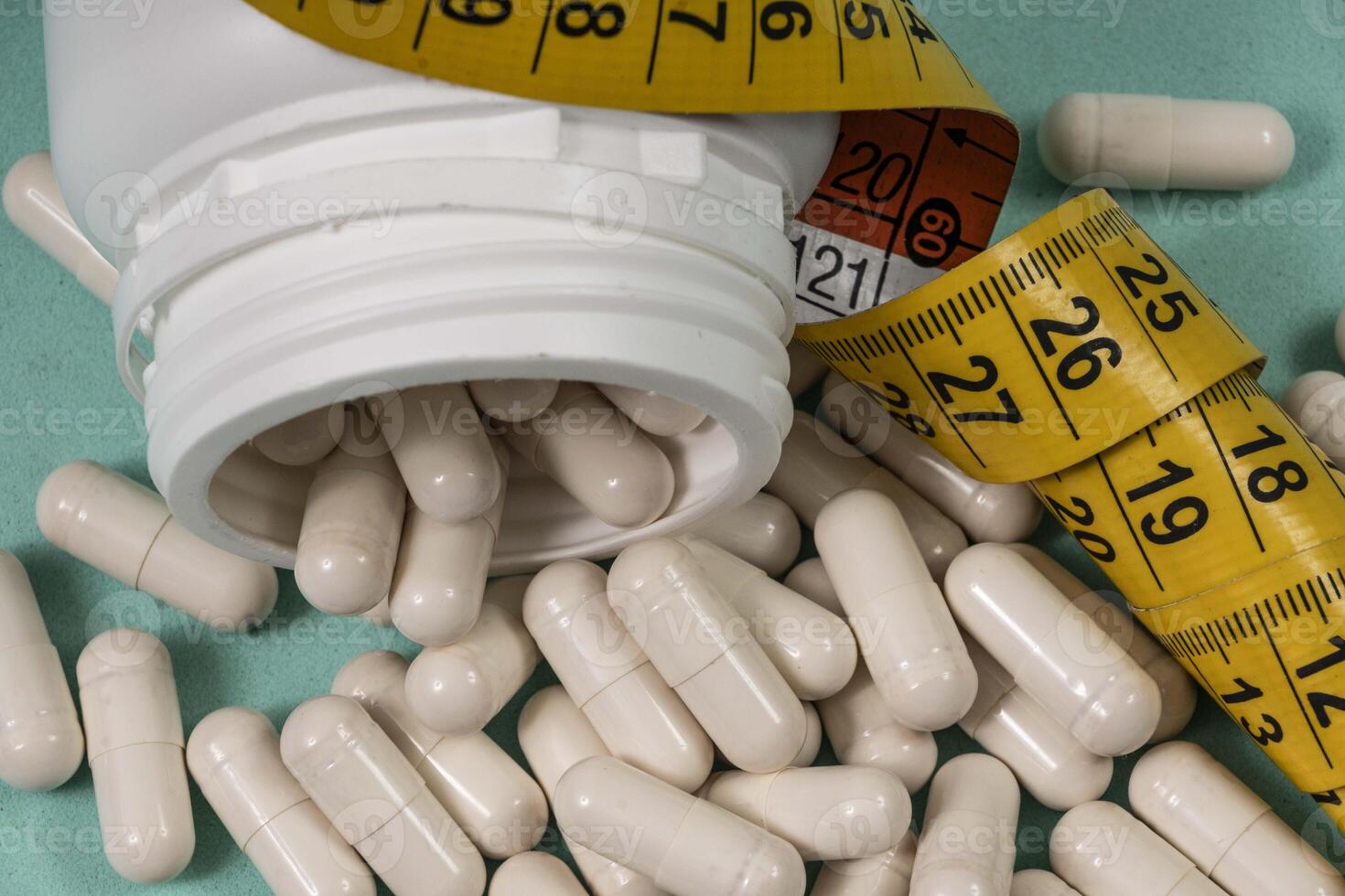 bottle of pills, some onto a light blue surface photo