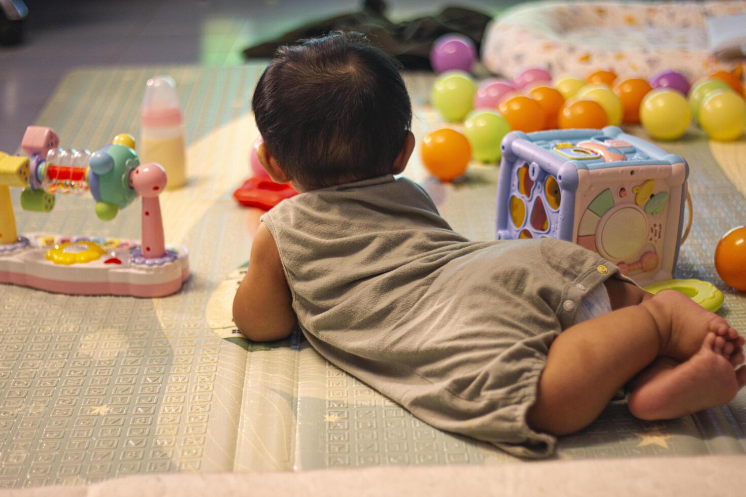 Baby In Bodysuit Is Crawling On A Soft Mat In The Room photo