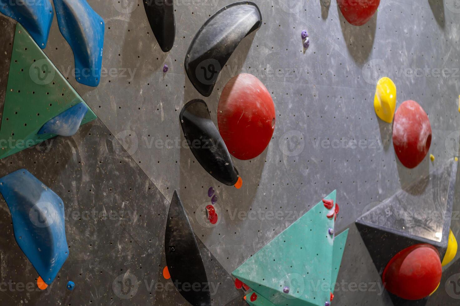 Colorful climbing holds on artificial rock climbing wall photo