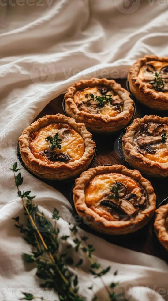 Mini chicken and mushroom quiches appear to float elegantly above a linen backdrop, showcasing their creamy filling and golden crust photo