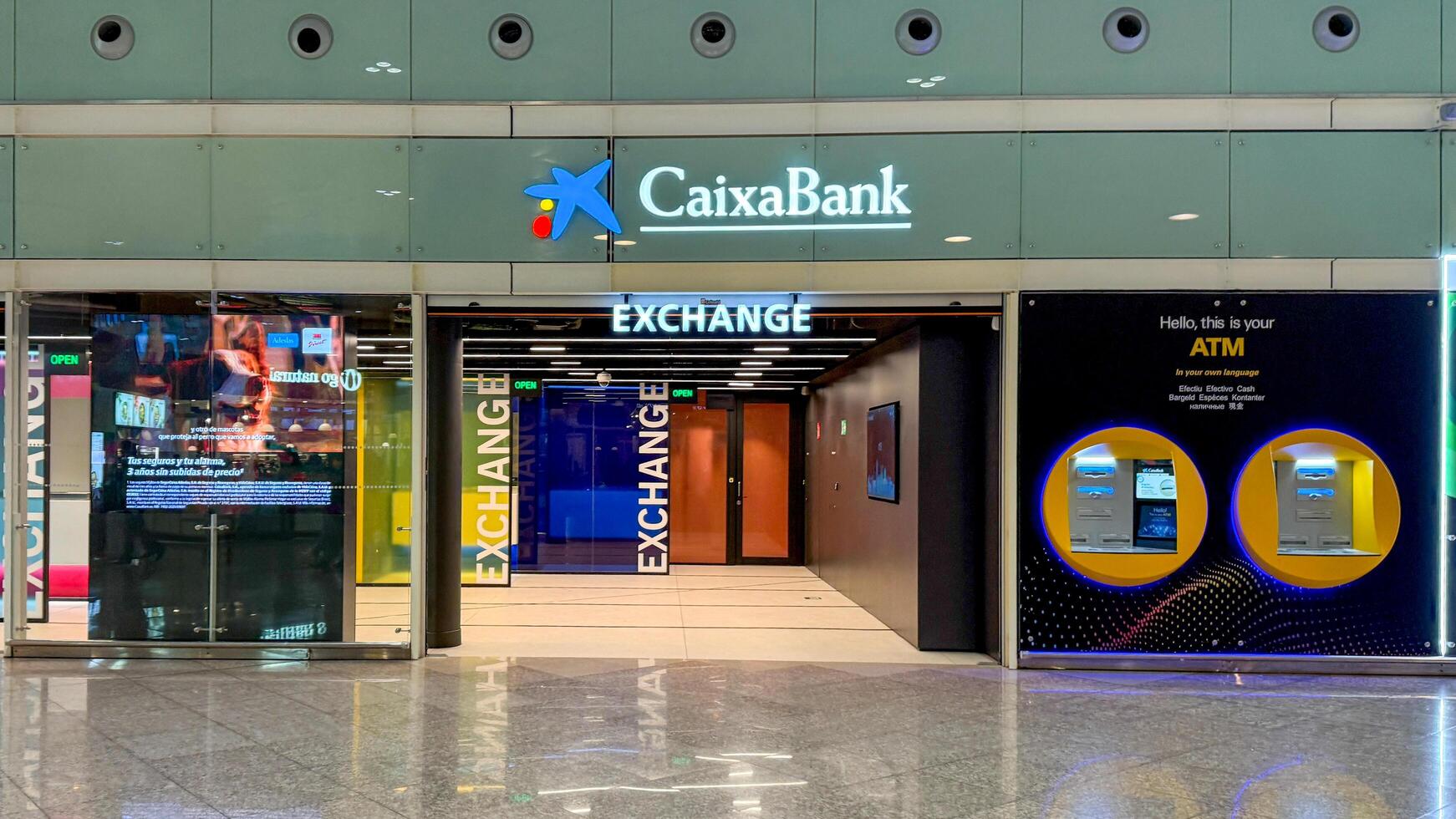 Front view of CaixaBank exchange office with ATM services, financial transactions, travel currency exchange March 16 2025, Barcelona, Spain photo
