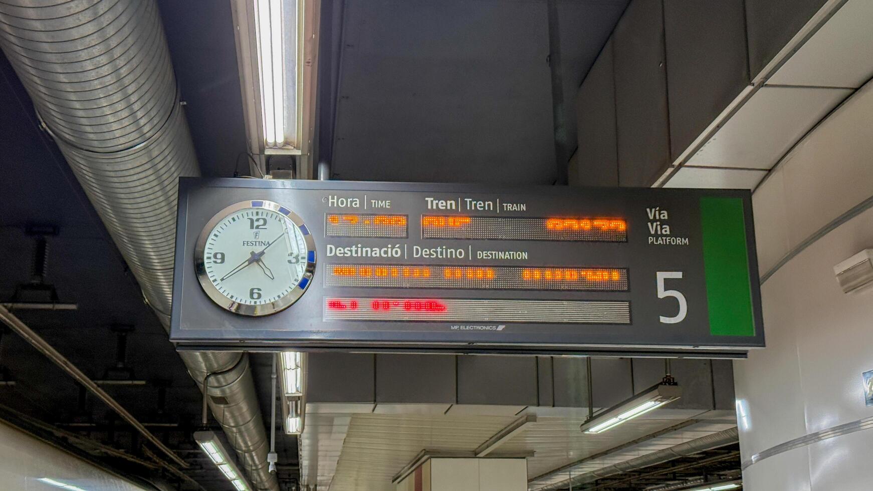 Train station departure board with clock, urban transit travel, public transportation logistics, modern commuting, March 16 2025, Barcelona, Spain photo