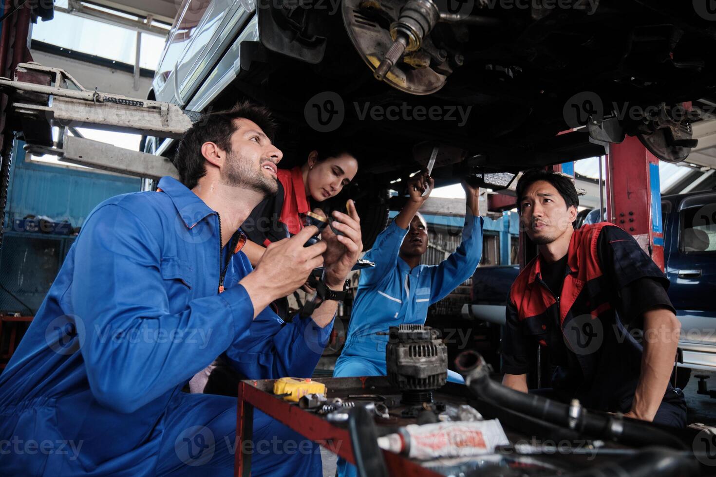 Professional multiracial workers teams, mechanical engineer coworkers cooperate to fix and maintain car suspensions together in garage station, and service jobs in automotive transport industry. photo