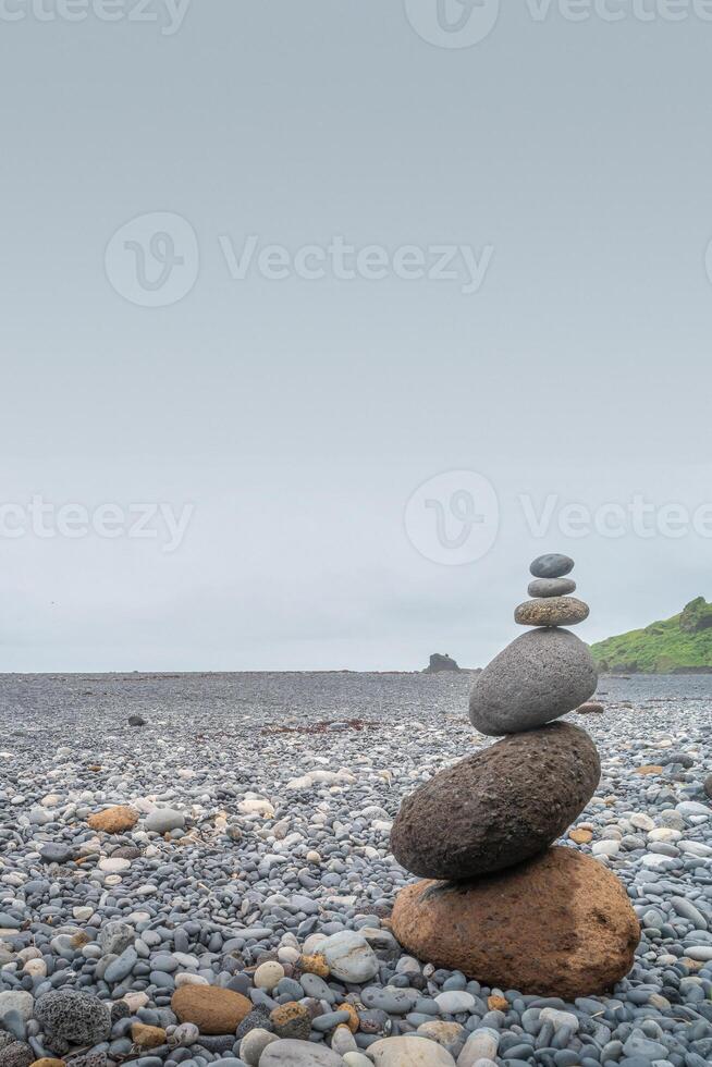 Cover page with view of pyramid made of stack of round stones put together at each other at stony gravel beach seacoast, copy space photo