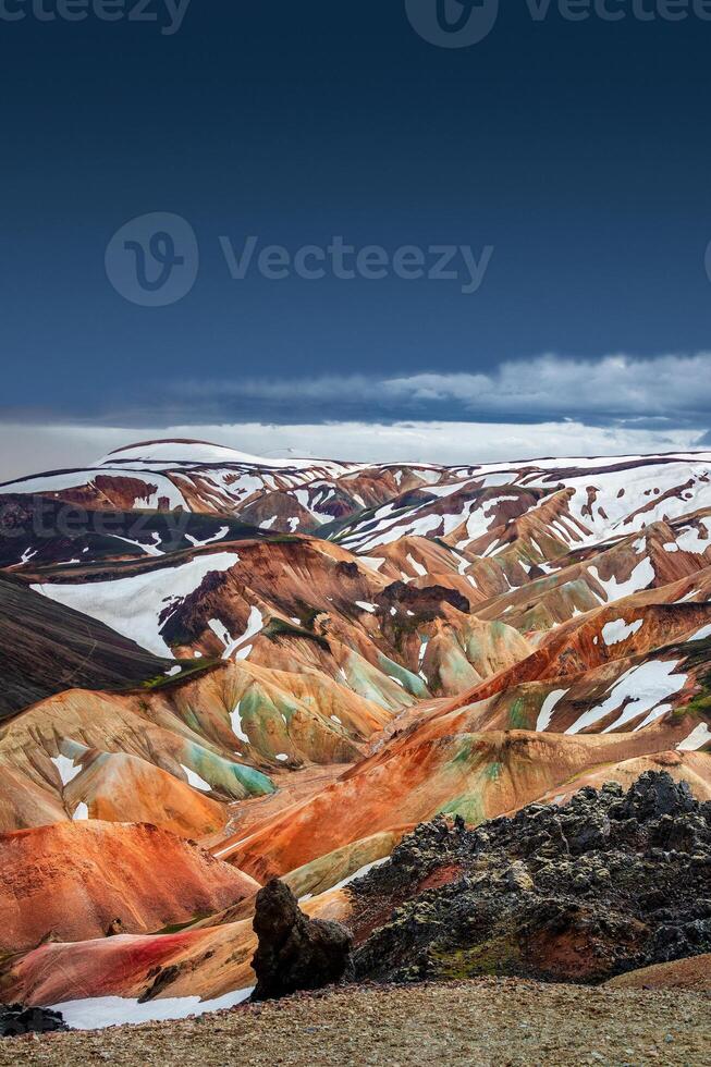 Beautiful Icelandic landscape of colorful rainbow volcanic Landmannalaugar mountains, famous Laugavegur hiking trail with dramatic sky and red volcanic soil in Iceland photo