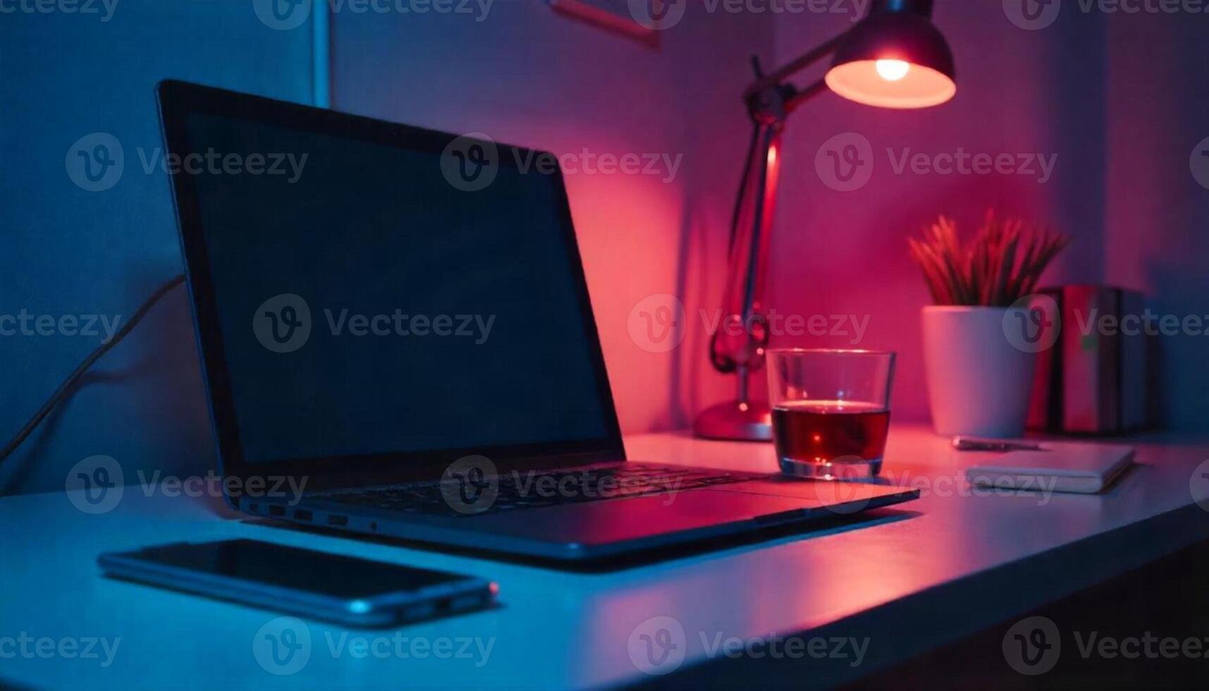 A laptop sitting on a desk with a red light photo