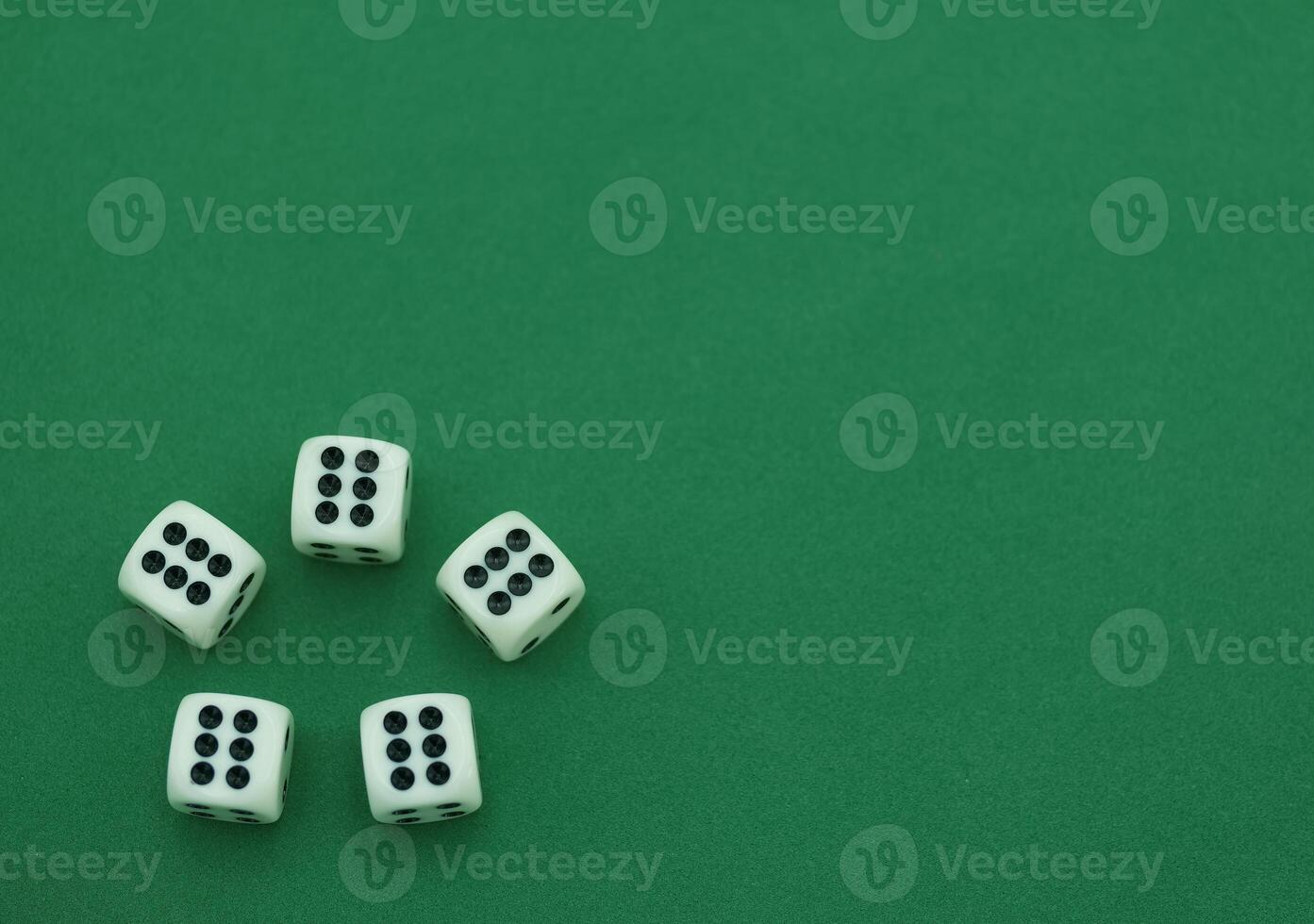 Five white dice arranged on a green surface showing various numb photo