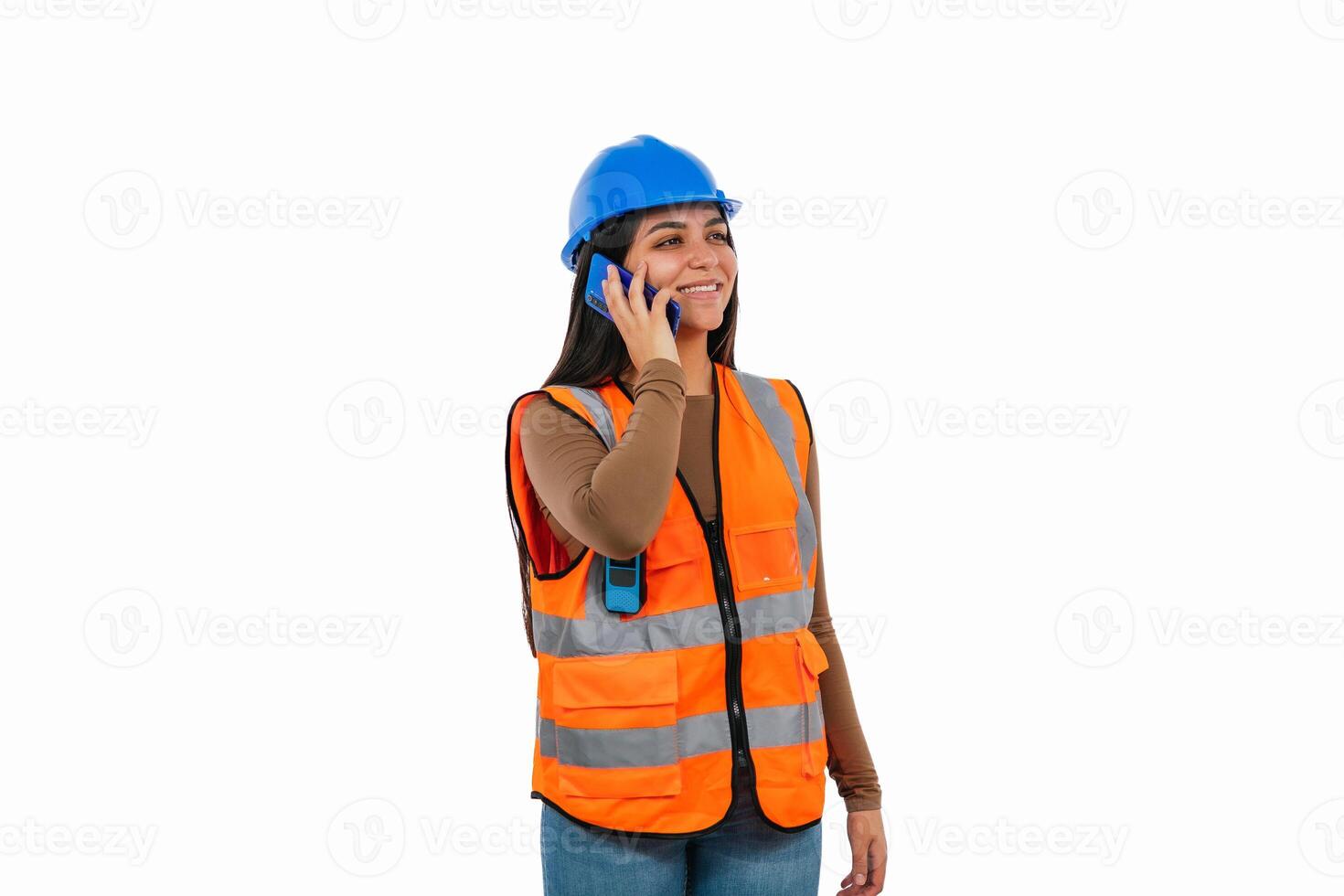 Smiling female engineer talking on smartphone wearing safety helmet and vest photo