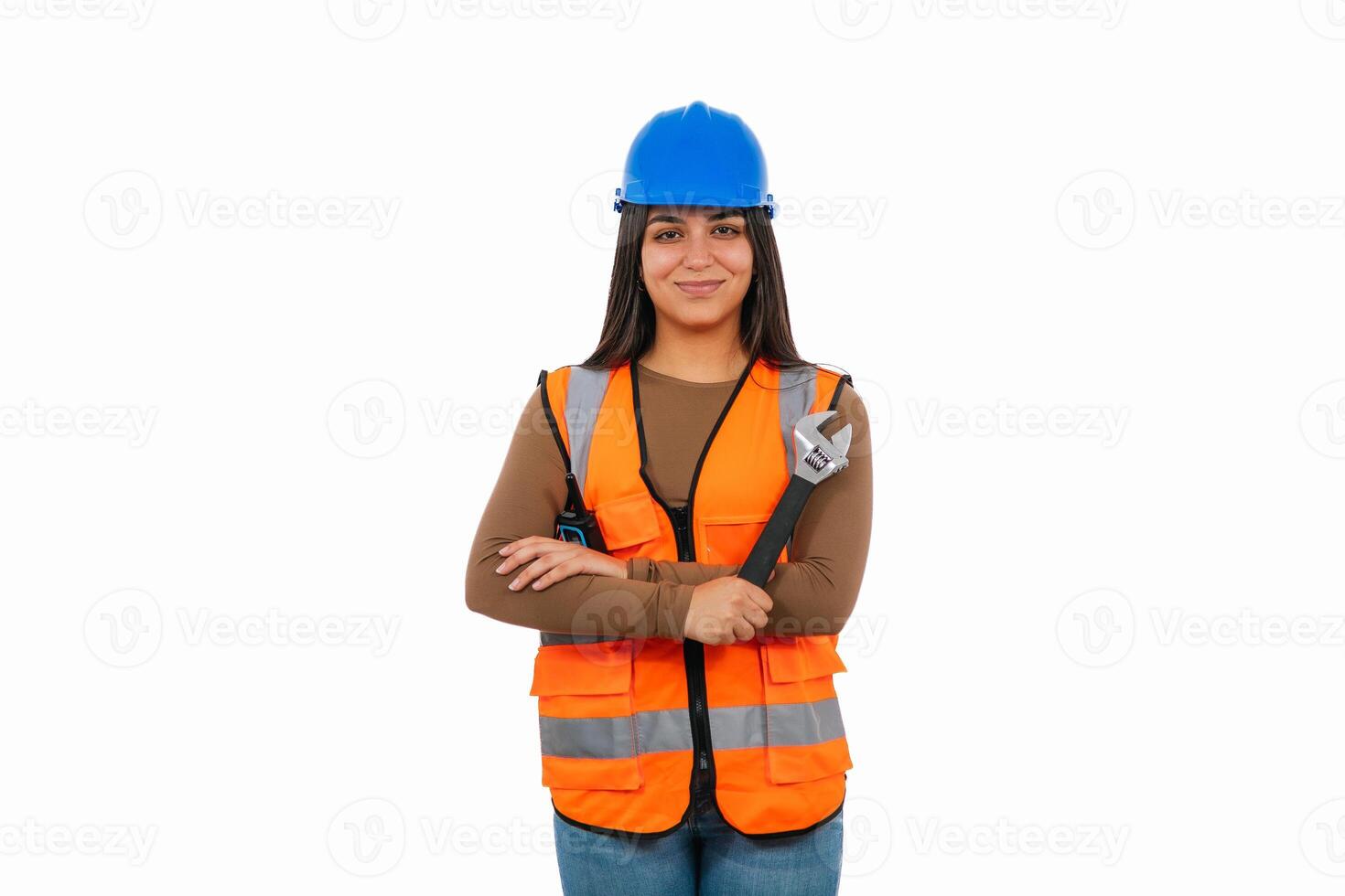 Confident latina construction worker holding adjustable wrench and wearing safety vest photo