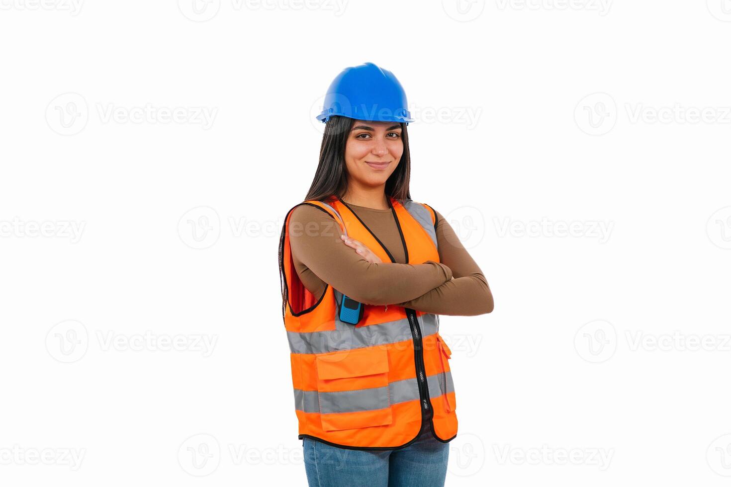 Confident female engineer wearing safety vest and hardhat posing with crossed arms photo